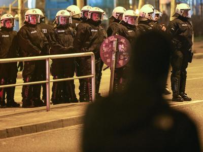 Ein Passant läuft in Hamburg im Schanzenviertel an Einsatzkräften der Polizei vorbei. Foto: Axel Heimken Gefahrengebiet