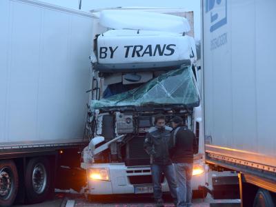 Lkw-Fahrer unterhalten sich nach dem schweren Unfall auf der Autobahn 5 bei Friedberg vor einem zerstörten Führerhaus miteinander. Foto: Arne Dedert Schwerer Unfall bei Friedberg