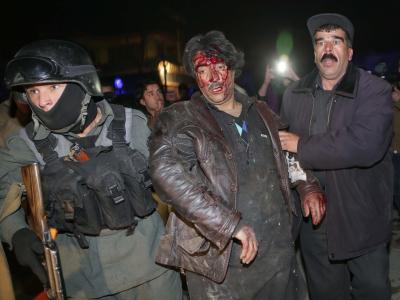 Afghanische Polizisten stützen ein Opfer des Anschlags in Kabul. Foto: S. Sabawoon Anschlagsopfer