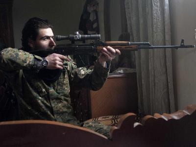 Ein Rebell zielt in Aleppo auf eine Stellung der Regierungsarmee. Foto: Bruno Gallardo Rebell in Aleppo