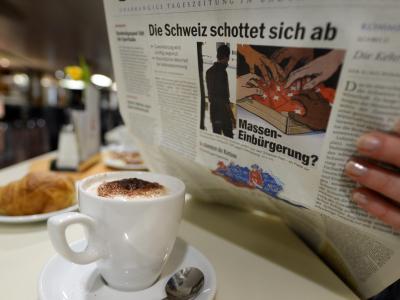 Eine Frau liest auf einer Fähre Richtung Konstanz eine Zeitung, die titelt Titelstory