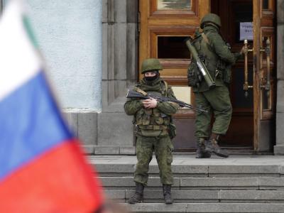 Bewaffnete und russische Flaggen vor einem Regierungsgebäude auf der Krim. Foto: Maxim Shipenkov Gespannte Ruhe