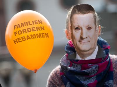 Demonstrantin bei einer Hebammen-Demonstration in Frankfurt am Main mit Gröhe-Maske. Der Bundesgesundheitsminister macht den freiberuflichen Geburtshelferinnen Hoffnung. Foto: Frank Rumpenhorst/Archiv Hebammen-Protest in Frankfurt/Main