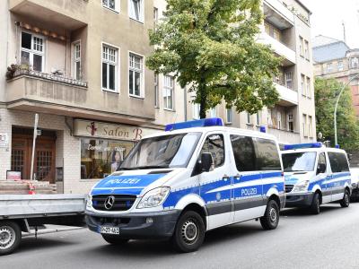 Polizeiwagen stehen während einer Razzia gegen Scheinehen vor einem Haus in Berlin. Foto: Paul Zinken Razzia