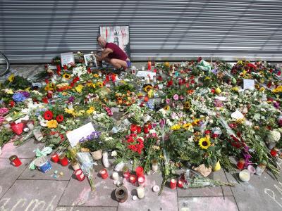 Blumen und Kerzen liegen am 30. Juli 2017 vor dem Supermarkt in Hamburg-Barmbek. Foto: Bodo Marks Blumen und Kerzen