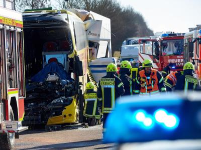 Nach dem Unfall zwischen einem Reisebus und zwei LKW stehen Helfer an der Unfallstelle. Foto: Thomas Frey Busunfall