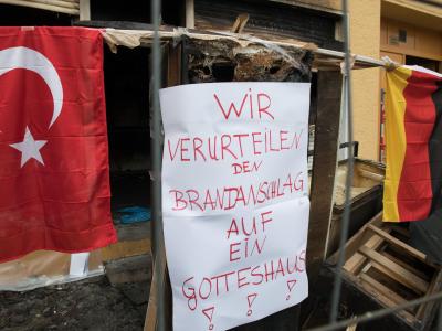 Plakate und Flaggen hängen vor einer Moschee an in Berlin-Reinickendorf, auf die ein Brandanschlag verübt wurde. Foto: Paul Zinken Berliner Moschee