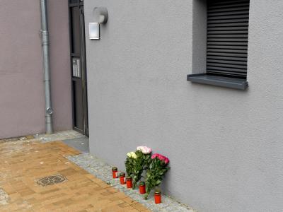 Blumen und Kerzen stehen an einem Mehrfamilienhaus. In dem Gebäude ist eine 17-Jährige nach Messerstichen gestorben. Foto: Carsten Rehder Gewaltsamer Tod