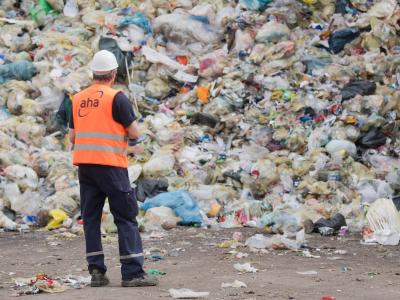 Ein Mitarbeiter einer Deponie vor einem Müllberg: In der Gelben Tonne landet oft Müll, der dort gar nicht hingehört. Foto: Julian Stratenschulte Müllberg