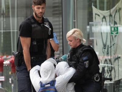 Polizeibeamte tragen einen Demonstranten aus der Landesvertretung von Nordrhein-Westfalen. NRW-Landesvertretung besetzt