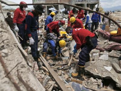 Feuerwehrleute auf der Suche nach Verschütteten. Erdbeben in Indonesien