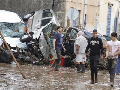 Einwohner von Sant Llorenc des Cardassar gehen nach dem schweren Unwetter an Autowracks vorbei. Unwetter auf Mallorca