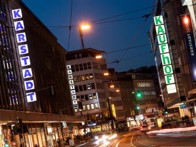 Filialen von Karstadt und Kaufhof liegen sich an einer Straße in Düsseldorf gegenüber. Karstadt und Kaufhof