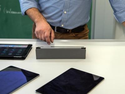Ein Lehrer bedient in einem Klassenzimmer in einer Schule einen Tabletcomputer. Lehrer mit Tablet