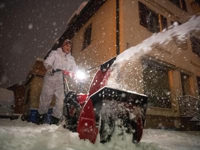 Rudolf Röckenschuß, Inhaber einer Metzgerei, befreit seinen Hof mit einer Schneefräse vom Schnee. Winter in Bayern