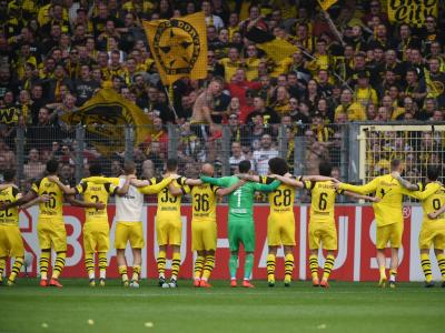 Die BVB-Profis feiern vor der Südkurve den 4:0-Sieg über Freiburg. Arm in Arm