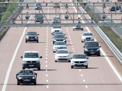 Autos fahren unter einer Mautbrücke auf der Autobahn A9 hindurch. Mautbrücke
