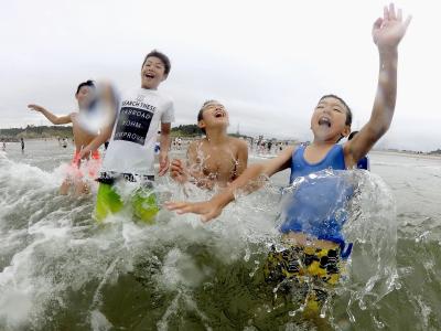 Kinder spielen im Wasser: Nach der Nuklearkatastrophe von Fukushima wurde der Strand zum ersten Mal wieder für Besucher zugelassen. Stranderöffnung