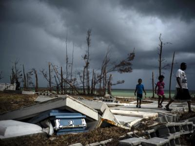 Menschen gehen an den Trümmern auf einem Friedhof auf den Bahamas vorüber. Nach Hurrikan «Dorian» - Bahamas