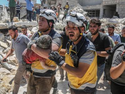 Weißhelme des syrischen Zivilschutzes tragen ein verletztes Kind aus den Trümmern eines zerstörten Gebäudes in der Provinz Idlib. Rebellengebiet Idlib