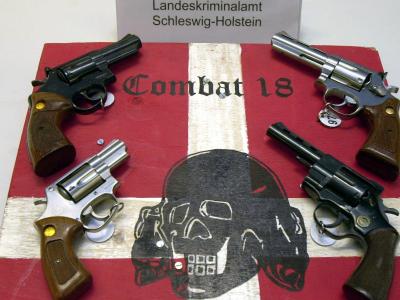 Sichergestellte Waffen und ein Schild der Neonazi-Gruppe «Combat 18» im schleswig-holsteinischen Landeskriminalamt. Verbot von Combat 18 gefordert