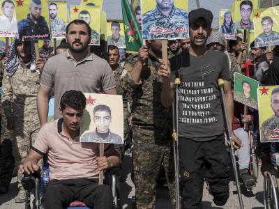 Verwundete kurdische Kämpfer präsentieren im nordostsyrischen Qamischli Bilder von Kameraden, die im Kampf gegen den IS getötet wurden. Kurdische Kämpfer