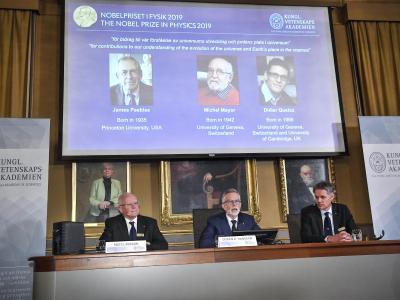 Der Nobelpreis für Physik geht in diesem Jahr an James Peebles (l-r auf der Leinwand), Michel Mayor und Didier Queloz. Physik-Nobelpreis