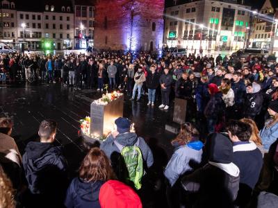 Trauernde stehen vor dem Roten Turm auf dem Marktplatz in Halle. Trauer nach Schüssen in Halle