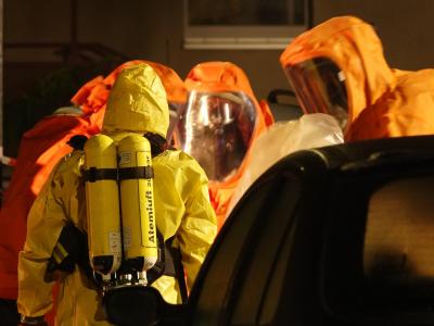 Feuerwehrleute sind in Schutzanzügen im Einsatz. Zwei tote Paketdienst-Mitarbeiter in Haldensleben