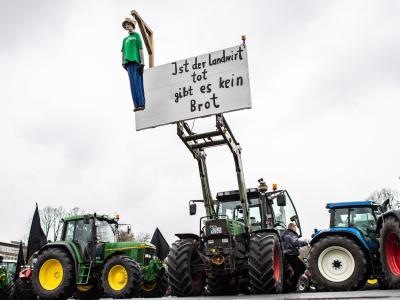 Eine Puppe hängt an einem Traktor und baumelt an einem Galgen mit dem Schild: Bauern planen Demonstration