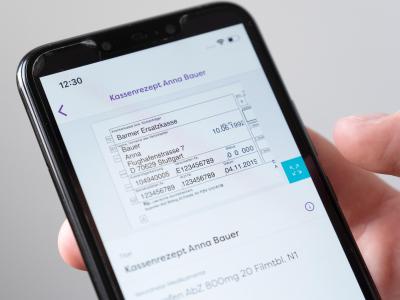 Auf einem Smartphone wird in einer App ein digitales Rezept einer fiktiven Patientin dargestellt. Gesundheits-App