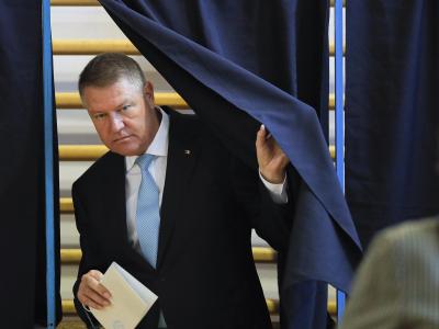 Klaus Iohannis, Präsident von Rumänien, verlässt eine Wahlkabine mit einem Stimmzettel. Präsidentenwahl in Rumänien