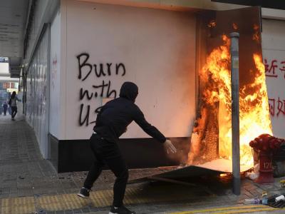 Ein Demonstrant setzt außerhalb der Bank of China im Central District von Hongkong Kartons in Brand. Proteste in Hongkong