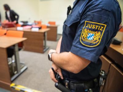 Ein Justizbeamter zu Beginn des Prozesses im Sitzungssaal vom Landgericht München II. Im Sitzungssaal