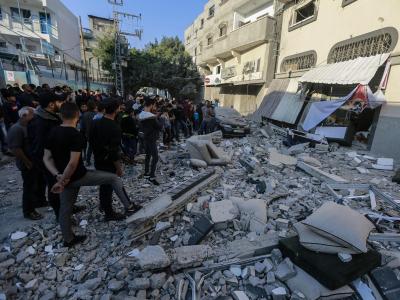 Anwohner und Passanten stehen nach dem israelischen Luftangriff vor dem beschädigte Haus von Baha Abu Al Ata. Nach dem Angriff