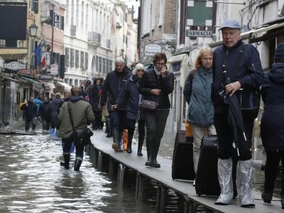Touristen ziehen ihr Gepäck über provisorische Gehsteige. Provisorische Gehsteige