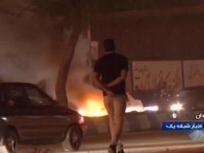 Das Videostandbild, das die staatliche Rundfunkgesellschaft der Islamischen Republik Iran zur Verfügung gestellt hat, geht ein Mann an einem Feuer vorbei, das von Demonstranten in Abadan gelegt wurde. Feuer