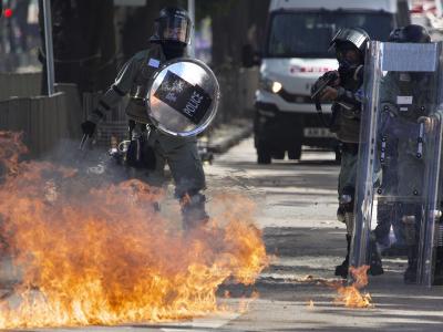 Ein Molotow-Cocktail geht vor Polizisten in Flammen auf. Proteste in Hongkong