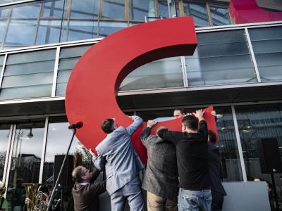 Mitarbeiter nehmen das C vor der Parteizentrale entgegen. Das C ist wieder da