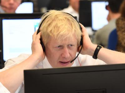 Großbritanniens Premierminister Boris Johnson sitzt mit anderen Kabinettsmitgliedern mit Headset vor einem Bildschirm an einem Tisch im Call Center des Hauptquartiers der Konservativen während des Wahlkampfs. Wahlkampf in Großbritannien