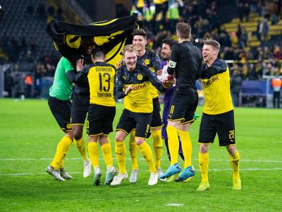 Nach dem Spiel gegen Slavia Prag tanzen Dortmunds Spieler erleichtert vor den Fans auf dem Spielfeld. Jubeltraube