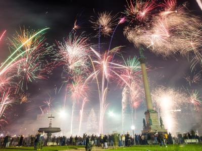 Zahlreiche Menschen feiern auf dem Schlossplatz in Stuttgart mit reichlich Feuerwerk in das neue Jahr. Menschen feiern Silvester