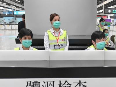 Vorsorge in Hongkong: Mitarbeiter des Gesundheitswesens untersuchen am Bahnhof West Kowloon Station Reisende auf ihren Gesundheitszustand. Hongkong