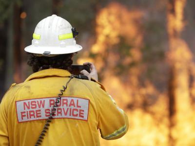 Ein Feuerwehrmann fotografiert mit seinem Smartphone eines der Buschfeuer bei Tomerong. Rund 2.300 Feuerwehrleute sind im Bundesstaat New South Wales bei etwa 110 Buschbrände im Einsatz. Buschbrände