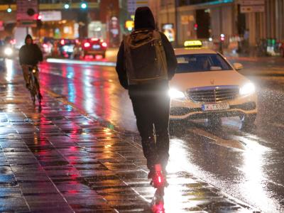 Ein E-Scooter fährt bei Regenwetter durch die Kölner Innenstadt. E-Scooter