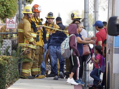 Einsatzkärfte vor Ort kümmern sich um Eltern und Kinder. Das Flugzeug musste den Treibstoff, um das Gewicht bei der Landung zu reduzieren. Feuerwehr vor Ort