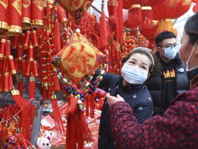 Nur mit Mundschutz: Menschen kaufen auf einem Markt in Fuyang Dekoration für das bevorstehende Neujahrsfest. Markt in Fuyang