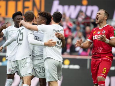 Bayerns Alaba (l-r), Müller, Coman und Lewandowski feiern das 2:0. Kölns Czichos (r) schreit und ärgert sich. 1. FC Köln - Bayern München