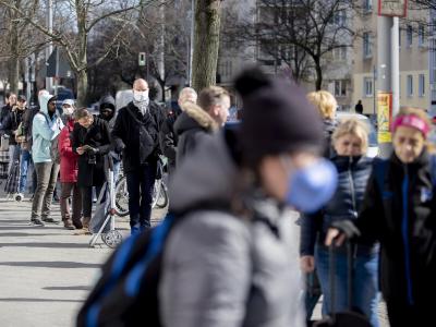 Zahlreiche Menschen stehen in Berlin vor einem Supermarkt Schlange. Supermarkt Berlin