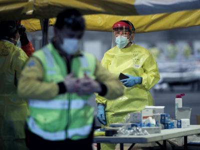 Gesundheitspersonal mit Schutzkleidung auf dem Gelände der Madrider Messe, wo Patienten mit leichten Symptomen behandelt werden. Corona-Zahlen in Spanien steigen
